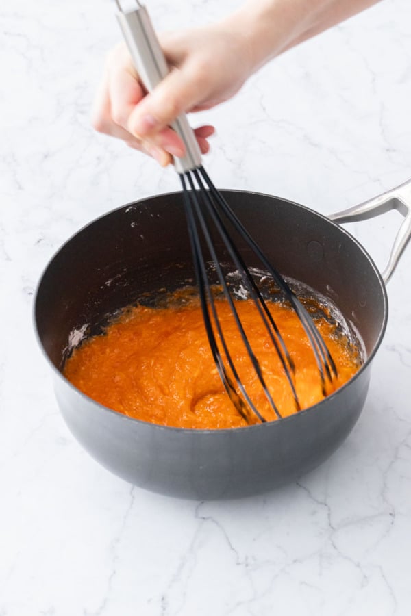 Whisking persimmon puree with tapioca starch until smooth.