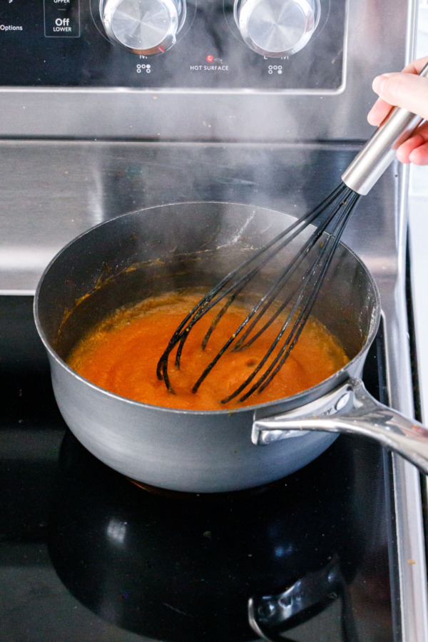 Simmering persimmon puree until slightly reduced.