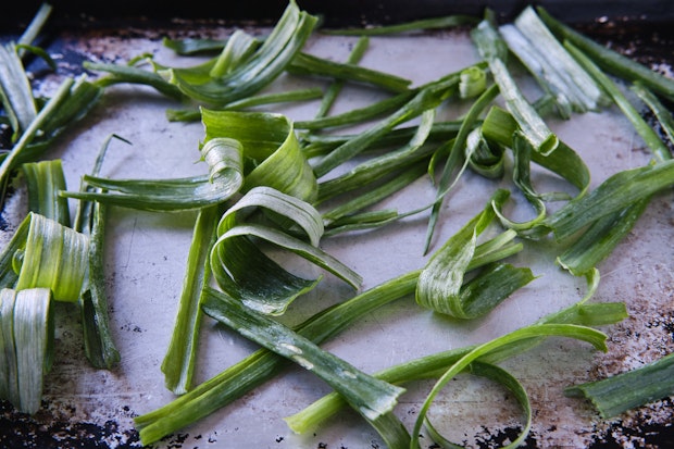 onion tops cleaned and arranged in a single layer on a sheet pan